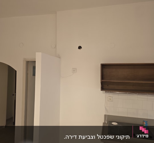 קיר צבוע עם חור קטן ליד מטבח